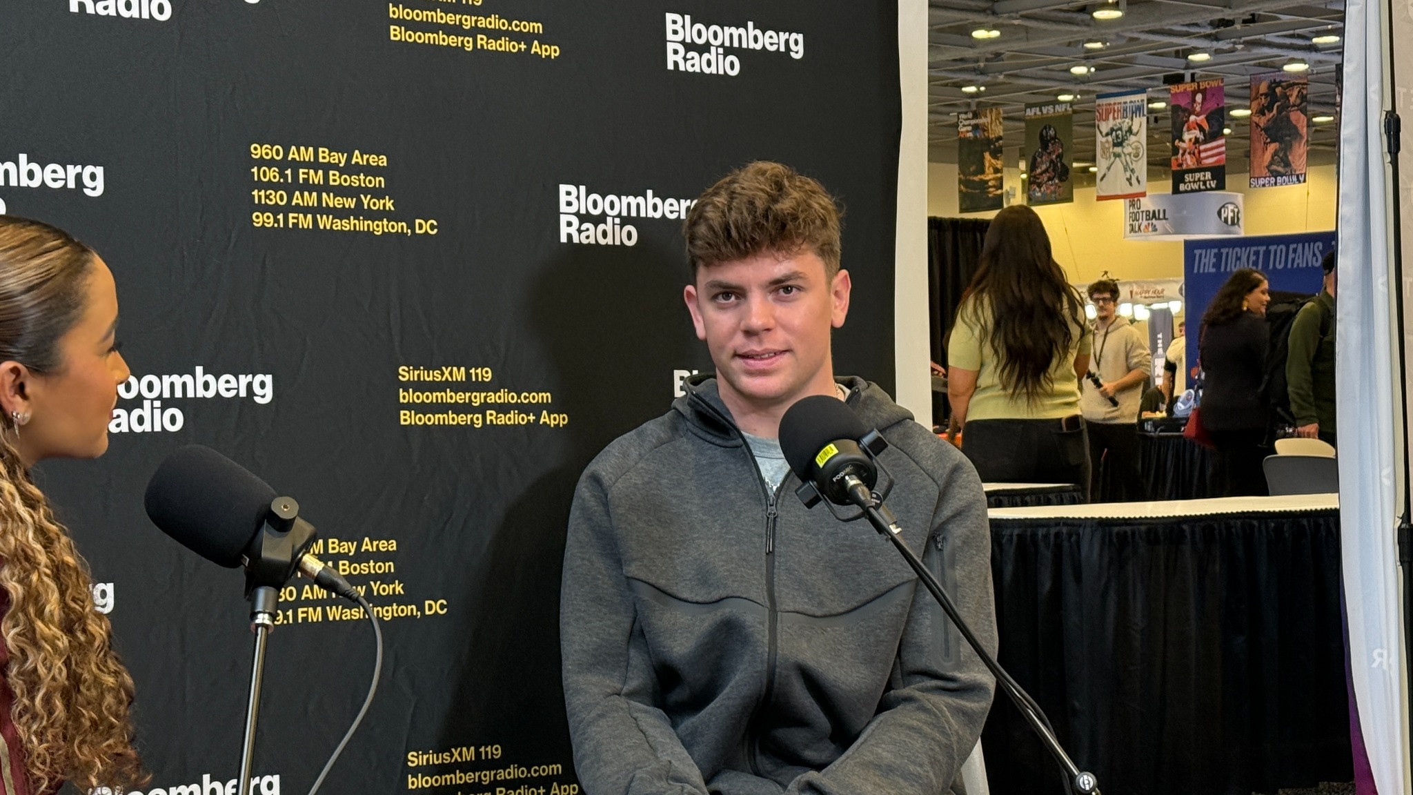 Supplied landscape photograph of a radio interview with two microphones in an event setting.